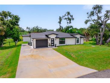 Beautifully landscaped home with a well-manicured lawn and a freshly painted exterior, showcasing its curb appeal at 326 Randolph Rd, Venice, FL 34293