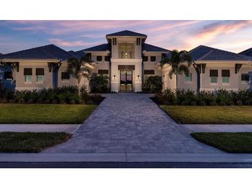 Stunning two-story home features beautiful landscaping and a brick driveway leading to the home's entrance at 1166 Blue Shell Loop, Sarasota, FL 34240