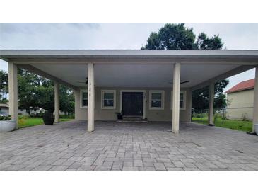 Charming single-story home with a large covered parking area and brick-paved driveway at 328 20Th W St, Palmetto, FL 34221
