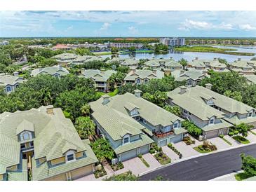 An aerial view of a beautiful neighborhood with green roofs and a lake in the background at 6536 Moorings Point Cir # 101, Lakewood Ranch, FL 34202