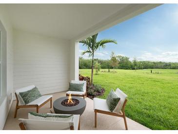 Inviting patio with comfortable seating, fire pit, and serene views of the lush green lawn at 9994 Key Haven Rd, Seminole, FL 33777