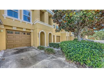 Charming townhome featuring a private garage, arched entryway, and manicured landscaping at 8823 White Sage Loop # 1802, Lakewood Ranch, FL 34202