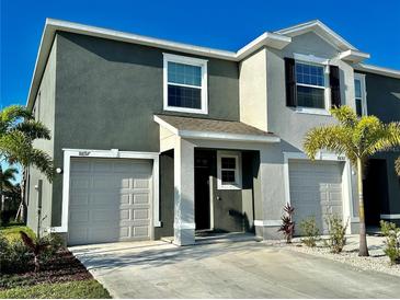 Attractive two-story townhome with attached garage and manicured landscaping at 8697 Milestone Dr, Sarasota, FL 34238