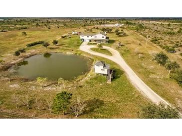 Aerial view showing the house, pond, and surrounding land at 48665 Bermont Rd, Punta Gorda, FL 33982