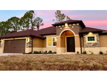 Beautiful home exterior with a two-car garage and landscaping at 4209 Titan St, North Port, FL 34286