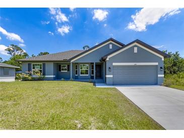 Charming single-story home featuring a two-car garage, well-manicured lawn, and inviting curb appeal at 3482 Dunkirk St, Port Charlotte, FL 33980