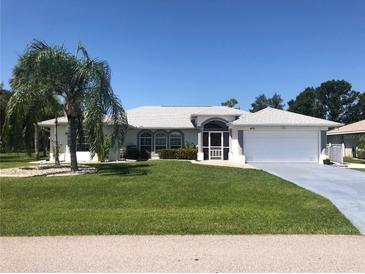 Single-story home with a white exterior, grey accents, and palm trees at 431 San Felix St, Punta Gorda, FL 33983