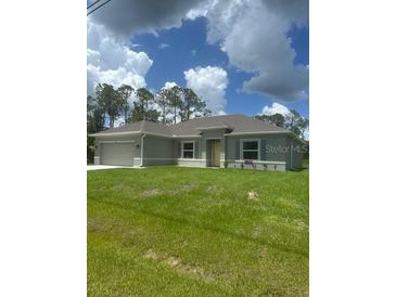 Charming one-story home with well-maintained lawn and attached two car garage at 5546 Wagon Wheel Dr, North Port, FL 34291