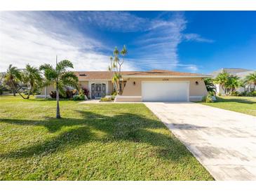 Tan single-story house with a white garage door and lush green lawn at 1759 Nuremberg Boulevard, Punta Gorda, FL 33983