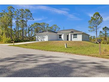 Newly constructed home with a two-car garage and a well-manicured lawn at 3297 Swanee Rd, Port Charlotte, FL 33980