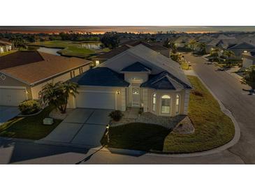 Night view of a single-story house with a well-maintained lawn at 1712 Lastingham Ln, Port Charlotte, FL 33980