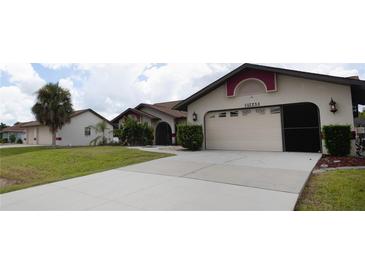 Two-car garage and front entrance of a charming house at 21445 Peachland Blvd, Port Charlotte, FL 33954