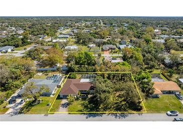 Expansive aerial view of home featuring large backyard, mature trees, and inviting swimming pool at 1150 Winston St, Port Charlotte, FL 33952