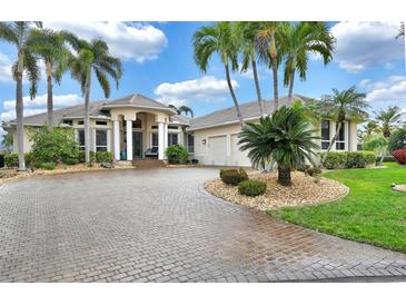 Two-story home with tile roof, palm trees, and circular driveway at 1700 Los Alamos Dr, Punta Gorda, FL 33950