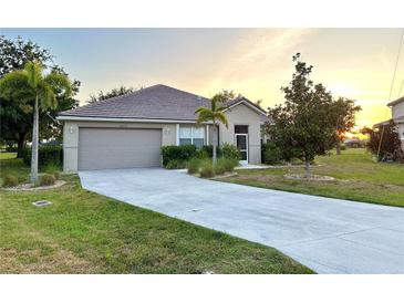 Well-maintained home with a large front yard and a two-car garage at 24479 Vienison Ln, Punta Gorda, FL 33955