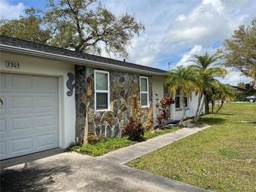 Ranch-style home with a stone facade and a two-car garage at 3303 Ithaca St, Port Charlotte, FL 33952