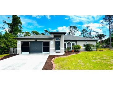 Single-story home with a two-car garage and well-maintained landscaping at 66 Wylam Dr, Port Charlotte, FL 33954