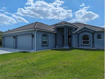 Two-story house with a gray exterior, three-car garage, and landscaping at 2761 Newman Dr, North Port, FL 34288