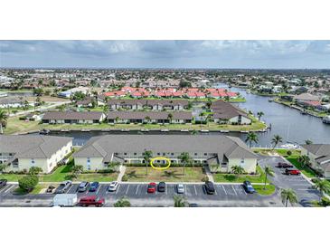 An aerial view of condo with beige exterior, parking and beautifully landscaped with waterfront and neighborhood views at 4000 Bal Harbor Blvd # 214, Punta Gorda, FL 33950