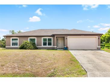 One-story home with brown stucco siding and attached garage at 4530 Irdell Ter, North Port, FL 34288