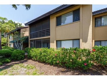 Charming two-story condo with a screened porch and well-maintained landscaping including vibrant flowering bushes at 5685 Ashton Lake Dr # 2, Sarasota, FL 34231