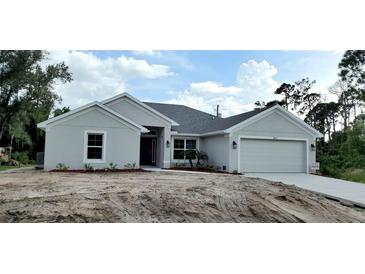 Newly built home with gray exterior and landscaping at 18321 Eblis Ave, Port Charlotte, FL 33948