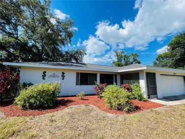 Single-story home with a landscaped yard and attached garage at 18300 Troon Ave, Port Charlotte, FL 33948