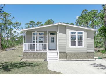 Exterior view of a light green single-story home with white trim and a front porch at 8191 Strasse Blvd, Punta Gorda, FL 33982