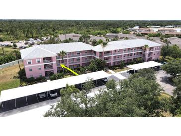 Pink condo building with parking and lush landscaping at 2061 Willow Hammock Cir # 202, Punta Gorda, FL 33983