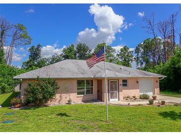 Charming light pink house with American flag at 7263 Sablon Rd, North Port, FL 34291