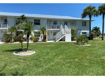 Two-story condo building with lush landscaping at 26470 Rampart Blvd # 123, Punta Gorda, FL 33983