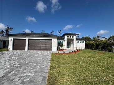 Beautiful one-story home featuring a three-car garage and well-manicured lawn and a paved driveway at 212 Fairway Rd, Rotonda West, FL 33947