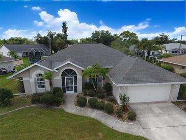 Beautiful single-story home featuring a well-manicured lawn and mature landscaping at 515 Allworthy St, Port Charlotte, FL 33954