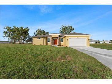 Charming single-story home with attached garage, manicured lawn, and inviting curb appeal at 16077 Coruna Ct, Punta Gorda, FL 33955
