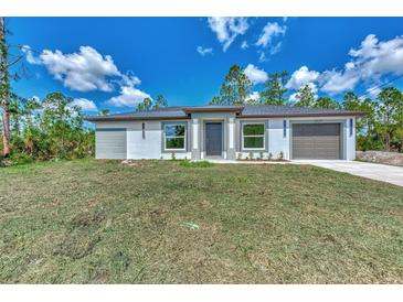 Newly built home with gray siding and a two-car garage at 4637 Corbett Ln, North Port, FL 34288