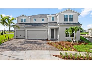 Two-story home exterior with three-car garage and landscaping at 42548 Little Ridge Rd, Punta Gorda, FL 33982