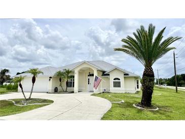 Beautiful single-story home with a large driveway and mature landscaping at 530 Kensington St, Port Charlotte, FL 33954
