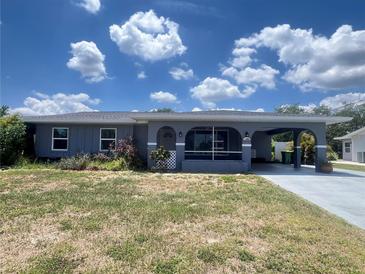 Charming single-story home with a covered carport and screened front porch nestled in a serene and established neighborhood at 1405 Dorchester St, Port Charlotte, FL 33952