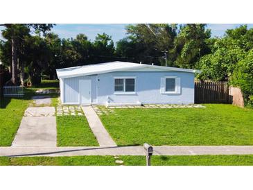 Ranch-style home with light blue exterior, a paved driveway and a well-maintained lawn at 8495 Cristobal Ave, North Port, FL 34287
