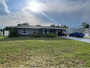 Gray house with green lawn and driveway at 1405 Dorchester St, Port Charlotte, FL 33952