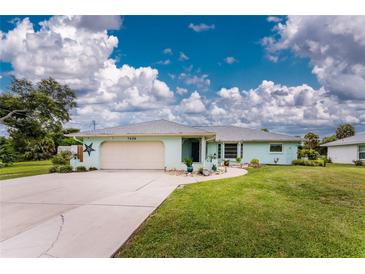 Front view of a charming light blue single-story house with a neatly landscaped lawn at 7456 Jennifer Dr, Port Charlotte, FL 33981