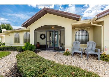 Inviting screened front entrance with a beautifully landscaped walkway and charming seating area at 2807 Via Paloma Dr, Punta Gorda, FL 33950