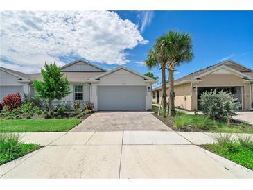 Two-story home with gray garage door and landscaping at 43614 Sparrow Dr, Punta Gorda, FL 33982