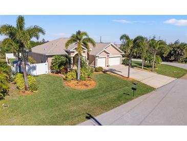 Single-story home with three-car garage and lush landscaping at 14176 Saul Ln, Port Charlotte, FL 33981