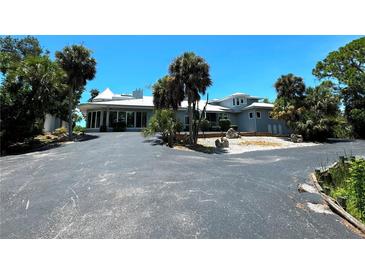 Two-story waterfront home with circular driveway at 1185 Bayshore Dr, Englewood, FL 34223