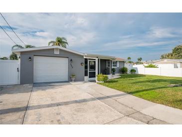 Gray house exterior with a garage and well-maintained lawn at 4049 Baden Dr, Holiday, FL 34691