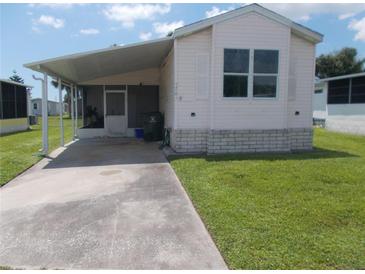 Single-wide manufactured home with carport and landscaped yard at 5787 Holiday Park Blvd, North Port, FL 34287