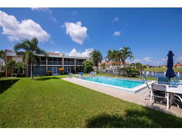 Community pool with lounge chairs and patio furniture at 3251 White Ibis Ct # C4, Punta Gorda, FL 33950