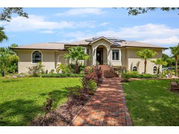 Single-story home with brick paver walkway, lush landscaping, and solar panels at 6242 Tropicaire Blvd, North Port, FL 34291