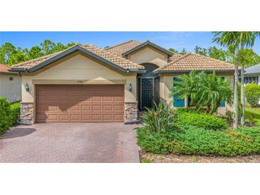 Attractive single-story home with a brown garage door and lush landscaping at 1596 Hyssop Loop, North Port, FL 34289